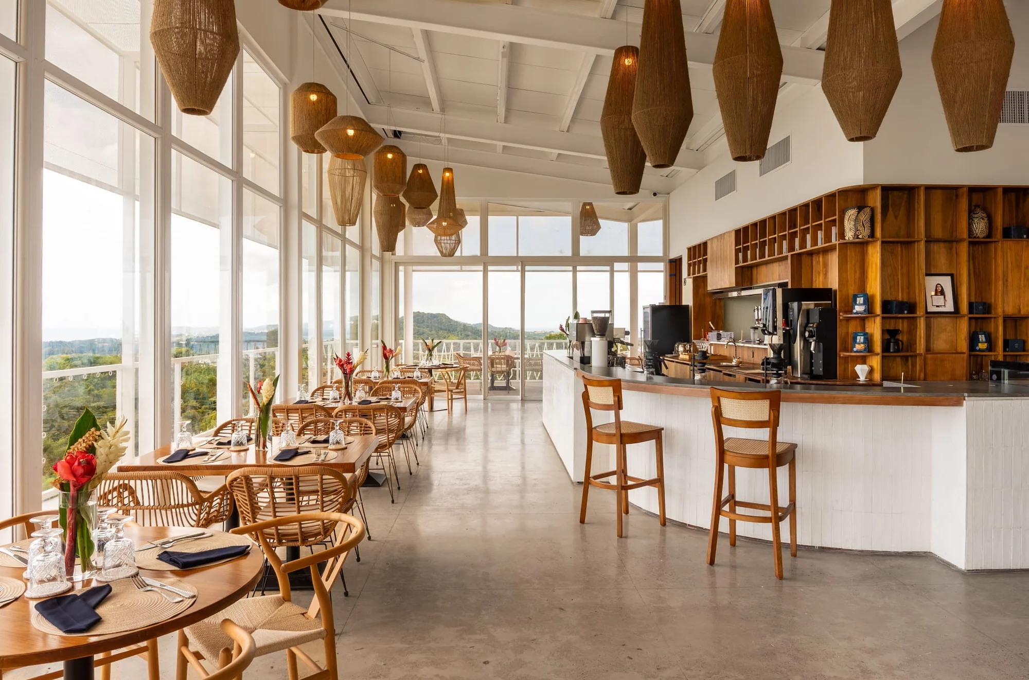 The From the Roots dining room, with woven pendant lights and windows onto the island
